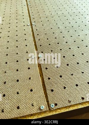 The wooden surface shows drilled holes and screws, indicating assembly or construction work in progress at a workshop. Stock Photo