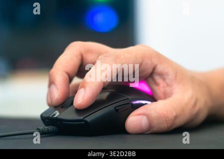Close up of hand holding a black computer mouse on mousepad for hardware and precision concept Stock Photo