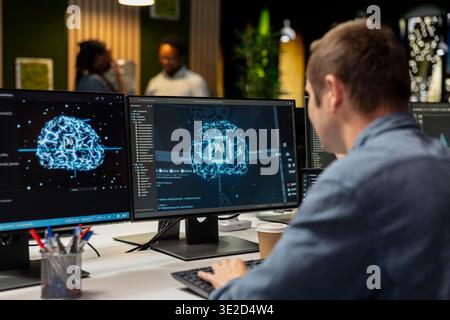 System administrator in tech startup office automating repetitive tasks using AI scripts on PC. IT expert using artificial intelligence application on computer to speed up feature implementation Stock Photo