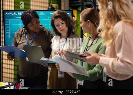 Strong diverse team of businesswomen works together on project analysis and finance reports in a modern corporate office, showcasing determination, efficiency and the power of networking. Stock Photo