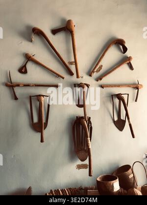 View of antiquated farm tools displayed on a pale wall, showcasing the rich agricultural heritage in Fada dutse, Dutse, Jigawa, Nigeria. Stock Photo