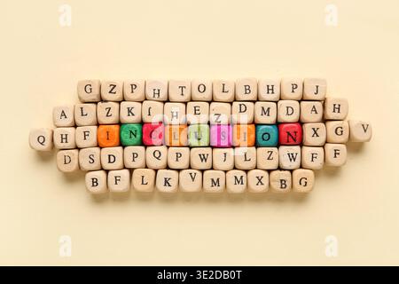Cubes with word INCLUSION and letters on beige background Stock Photo