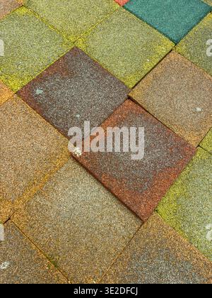 Several paving stones of different colors are laid out in a square pattern on the ground. This setup is seen in an outdoor area during the day under n Stock Photo