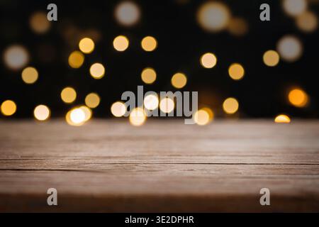 Wooden table with blurred lights on black background, bokeh effect. Stock Photo