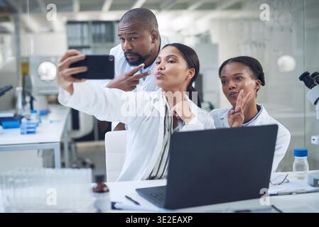 Laptop, selfie and team of scientists in laboratory with memory for pharmaceutical development. Computer, meeting and biologists with photography Stock Photo