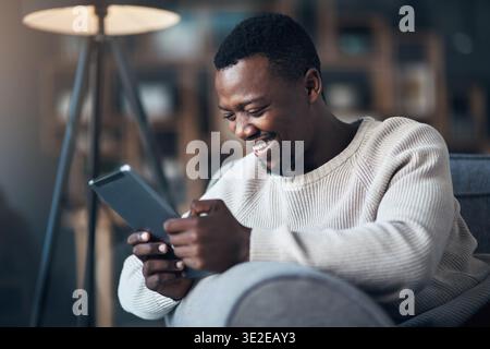 Relax, black man and laugh with tablet in home for comedy movie, funny online show and weekend break. Happy, person and digital app on sofa for Stock Photo