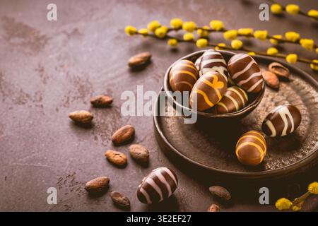 Sweet chocolate eggs with cocoa beans in brown tone for Easter Stock Photo