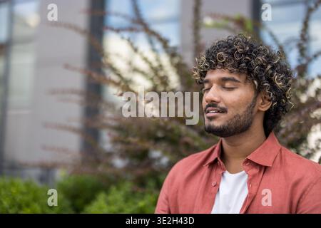 Close-up photo of a young Indian man with his eyes closed, relaxed and meditating. Stock Photo