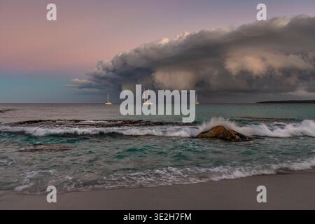 Dramatic sunset hues as a storm front nears three sailing boats off Tasmania's east coast. Stock Photo