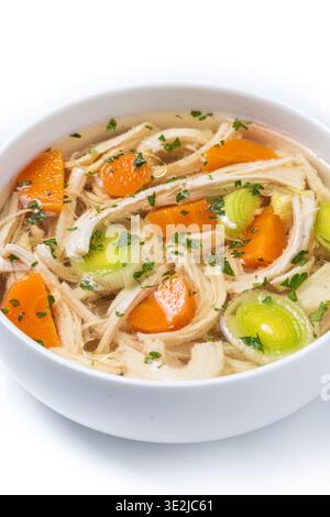 Homemade chicken soup in white bowl with carrots and celery isolated on white background Stock Photo