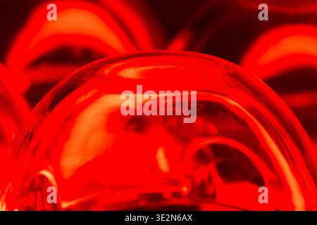 An abstract composition of an upside down plastic egg carton reflecting red light from below. Stock Photo