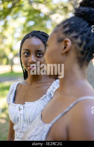 Black siblings interacting outside in a park Stock Photo