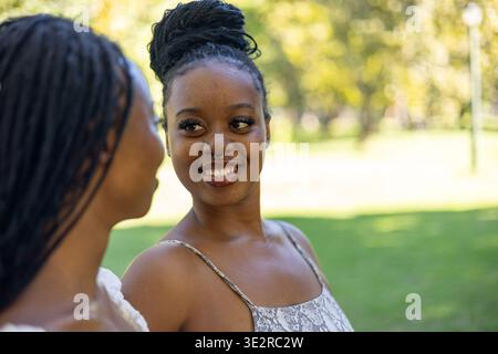 Black siblings interacting outside in a park Stock Photo