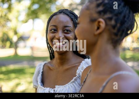 Black siblings interacting outside in a park Stock Photo