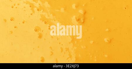 Warm yellow and orange liquid with bubbles creating an abstract textured background Stock Photo