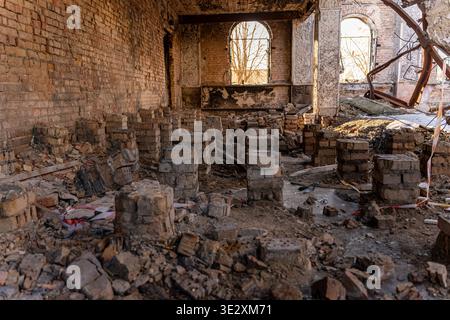 Irpin, Ukraine - 07 March 2026: View of the Irpin House of Culture, now a skeletal ruin with brick columns amidst rubble, under the sky's muted light. Stock Photo