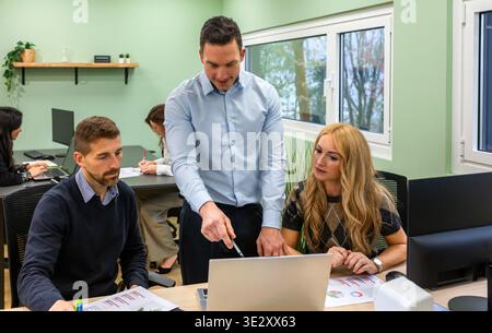 Business people collaborating on a laptop during a meeting in coworking office located in the forest Stock Photo