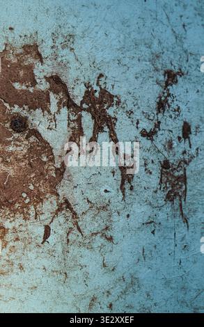 An old wooden plank with peeling blue paint, brown abstract stains, and scratches. Stock Photo