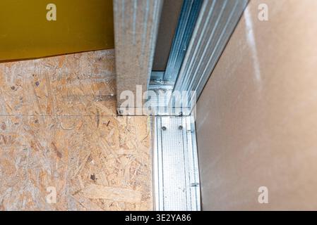 Drywall construction showing plasterboard attached to metal framing profiles on an osb subfloor Stock Photo