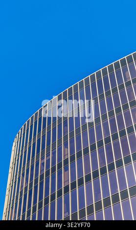 closeup image of the exterior of a modern glass skyscraper against a clear blue sky Stock Photo
