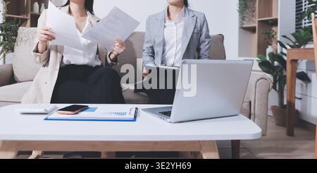Businesswomen reviewing paperwork in conference room Stock Photo