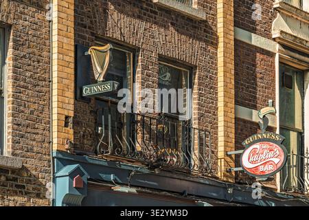 Traditional Guinness toucan signage and historic brick facade of Chaplin's Bar in Dublin city centre. Stock Photo