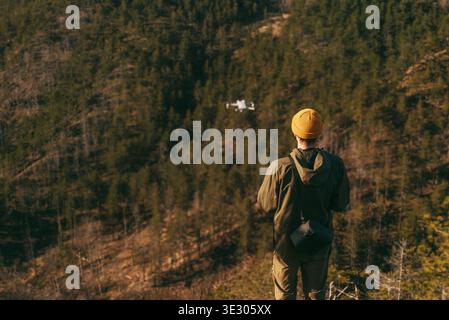 Man Tourist Flying Small Drone in Mountain Stock Photo