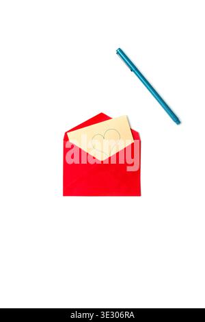 A red envelope with a beige love card featuring a hand‑drawn heart, placed on a clean minimalistic background with a pen. Stock Photo