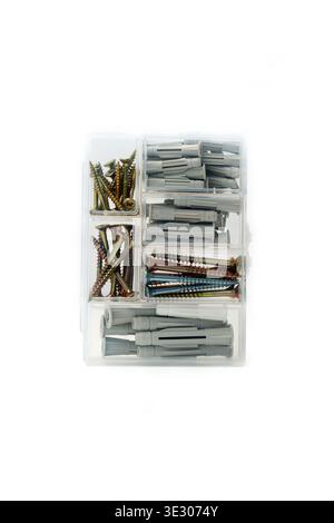 Vertical shot of a plastic organizer box filled with various wood screws and plastic wall plugs isolated on white background. Stock Photo