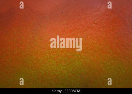 Abstract urban street art background. Yellow paint splashes on orange wall surface. Part of graffiti on building wall Stock Photo