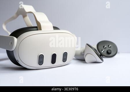 Modern virtual reality headset with controller on white surface, concept of VR gaming, immersive experience and advanced technology Stock Photo