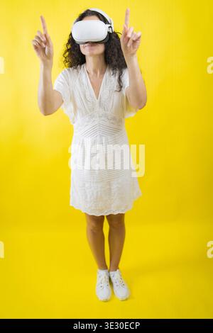Woman experiencing virtual reality wearing vr headset and headphones Stock Photo