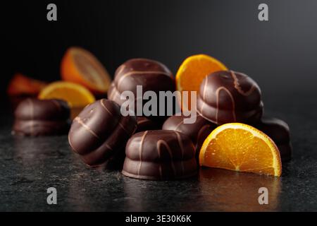 Cookies with dark chocolate and orange marmalade. Chocolate dessert with slices of fresh oranges on a black background. Stock Photo