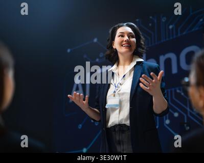 Empowering image of a confident female professional presenting groundbreaking AI concepts at a technology conference. The dynamic atmosphere, immersiv Stock Photo