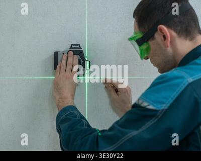 A man measures distance with a laser level.  Stock Photo
