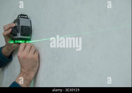 A man measures distance with a laser level.  Stock Photo