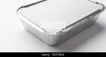 Mockup of a rectangular aluminum food container with a white paper lid, isolated on a white background. Stock Photo