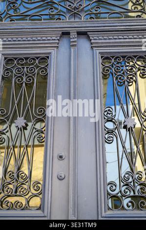 Ornate Art Deco double doors with decorative wrought iron grillwork and scrollwork details Stock Photo
