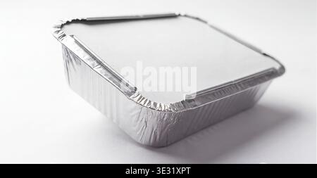 Mockup of a rectangular aluminum food container with a white paper lid, isolated on a white background. Stock Photo