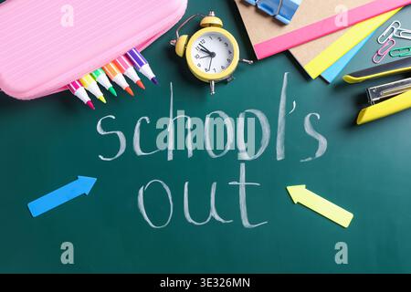 Phrase School's Out and school supplies on chalkboard, flat lay Stock Photo