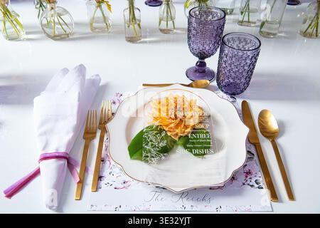 Elegant Wedding Reception Table with Purple Glassware and Floral Centerpieces. Beautifully styled wedding reception table. Stock Photo