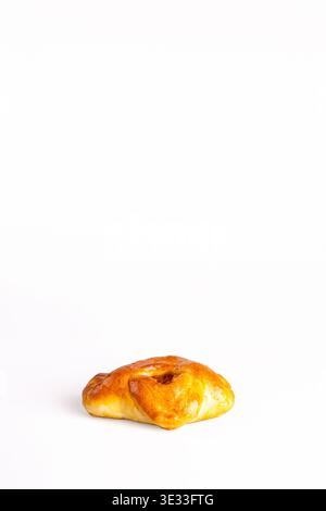 Freshly baked soft bun with glossy golden-brown crust and visible dried apricot filling peeking through, isolated on pure white background. Stock Photo