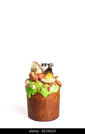 Easter kulich with vibrant green icing adorned with golden eggs, black bunny, and floral elements. Perfect for festive tables and religious traditions Stock Photo