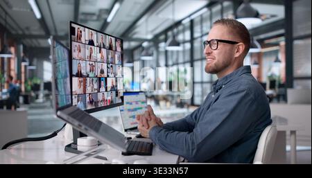 Business Manager Engages In Online Webinar, Communicating Via Computer During Virtual Meeting Stock Photo