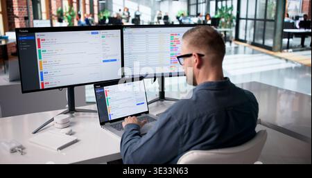 IT Specialist Diligently Oversees Network Security And Support Ticket Management Stock Photo