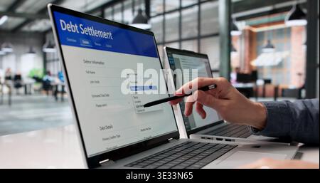Financial Consultant Analyzing Digital Debt Relief Documents Across Several Monitors Stock Photo