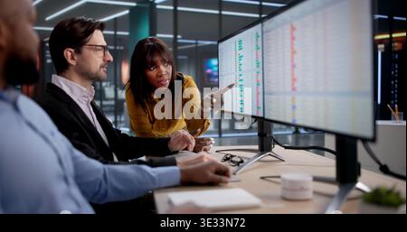 Diverse Team Of Healthcare Analysts And Coders Review Medical Reports Carefully, Using Computers. In The Office Stock Photo