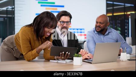 Diverse Team Collaborates Using Kanban Software, Planning Schedules On Laptops Stock Photo