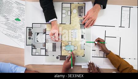 Real Estate Agent Showing Apartment Design Plans While Discussing Remodel Project. An Interior Designer Working Stock Photo
