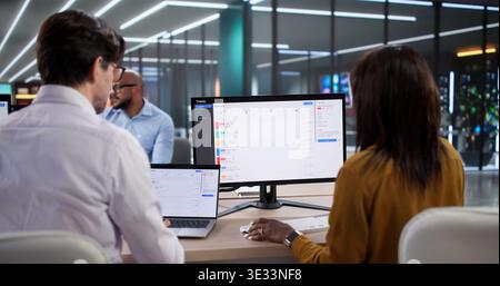 Diverse Team Of People Using Computers For Technical Support And Diagnostics. Man And Woman Working Together On Laptop Stock Photo